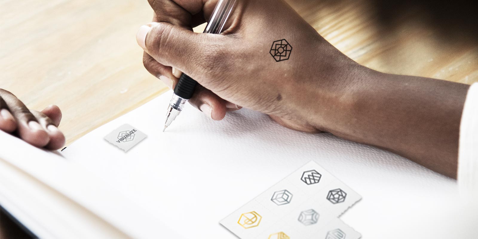 Young professional woman combining the mindfulness exercises of journaling with our temporary tattoo symbolizing “visualize"