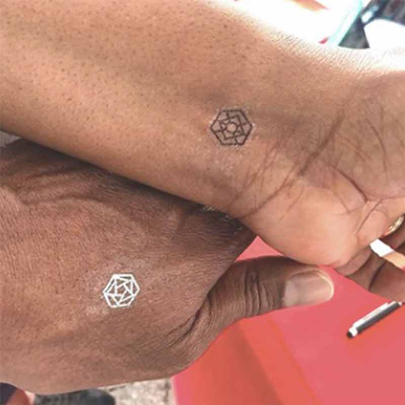 A couple lovingly touching each others hands, showing off their mindful marks.