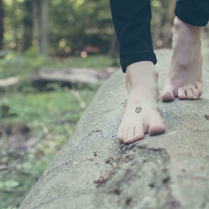 bare feet grounding with mindfulness tattoo representing center and self trust