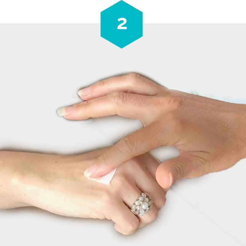 A woman presses her dampened mindful mark with gentle pressure on her hand. 