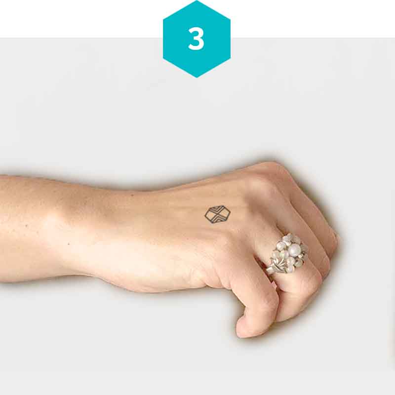 Woman showing a mindful mark on her hand that represents “communicate - I listen and express myself openly." 