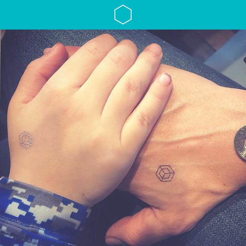 Mom and Son holding hands both wearing Center mindfulness temporary tattoos.