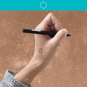 Woman wearing create mindfulness tattoos while holding pen in air with stars in the background.