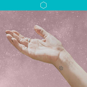Woman lifting palm to the sky wearing Attract Mindful Mark.